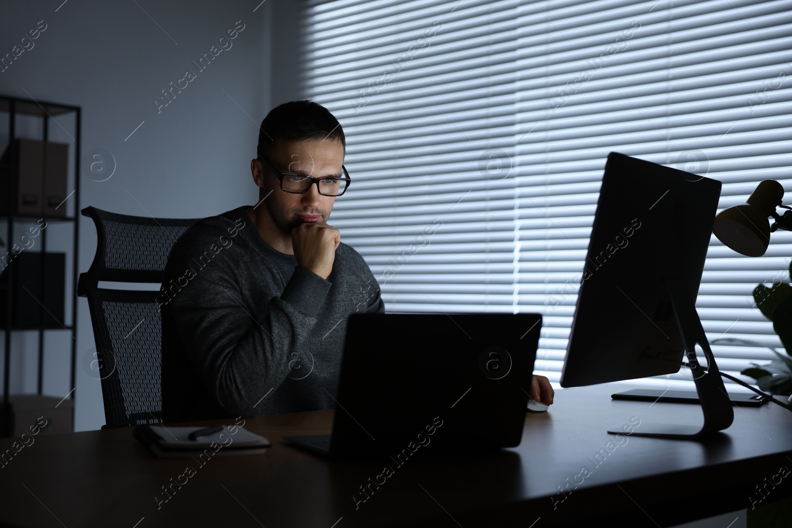 Photo of Programmer working on laptop indoors at night