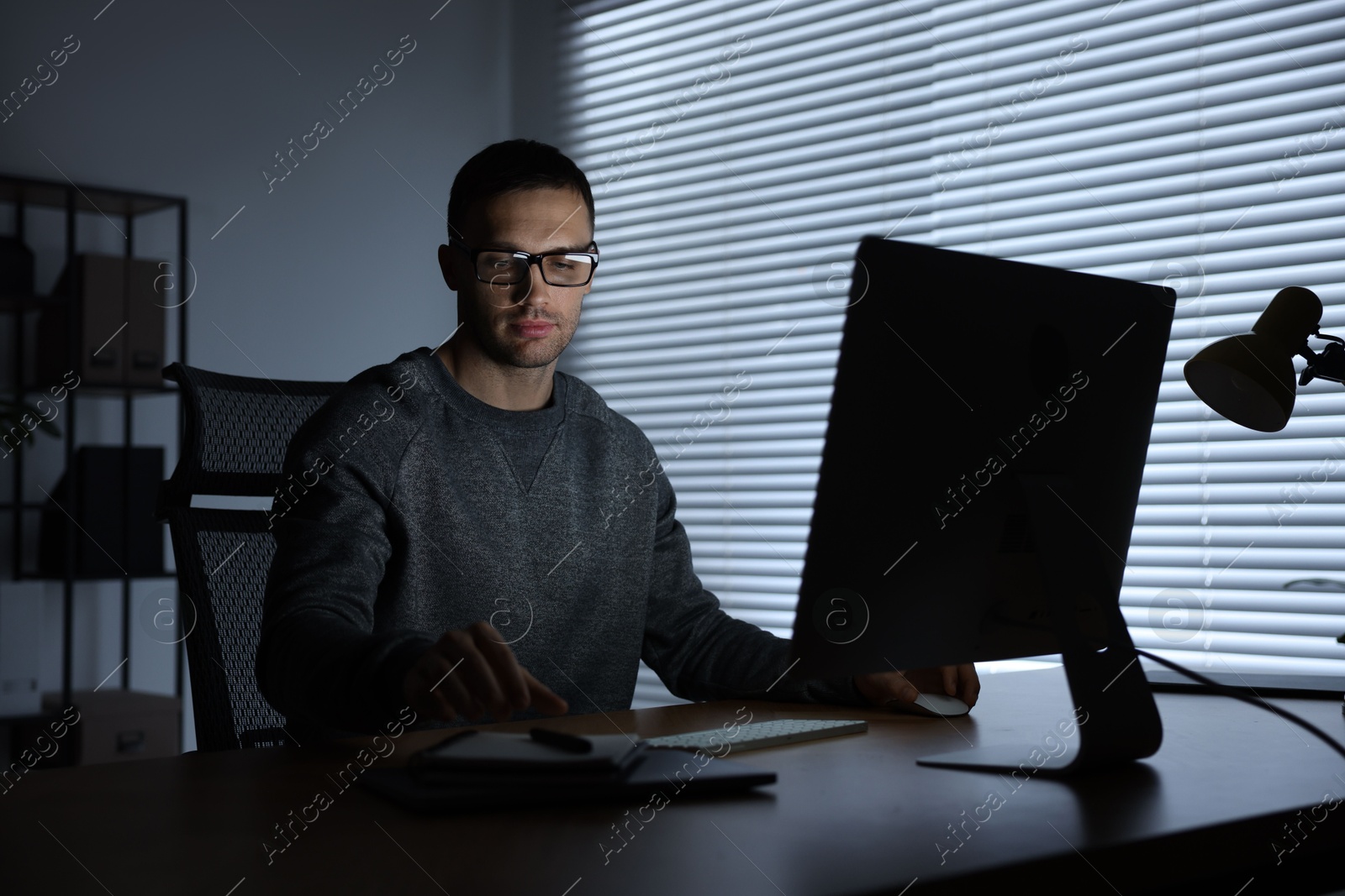 Photo of Programmer working on computer indoors at night