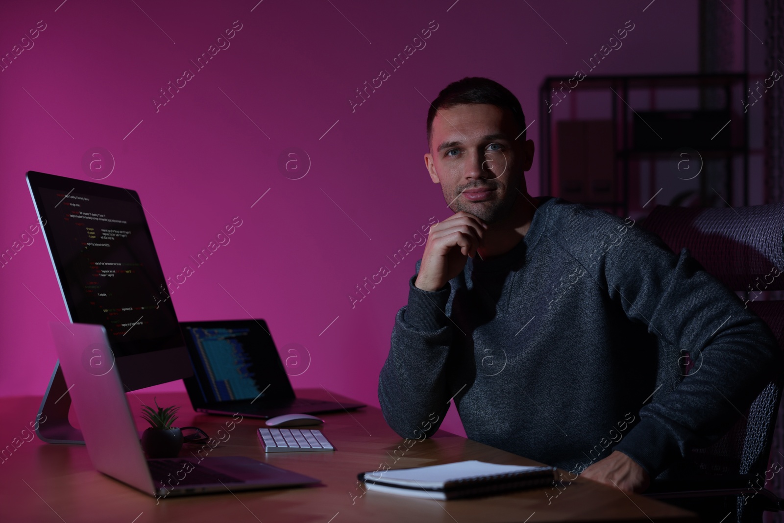 Photo of Portrait of programmer at wooden desk indoors