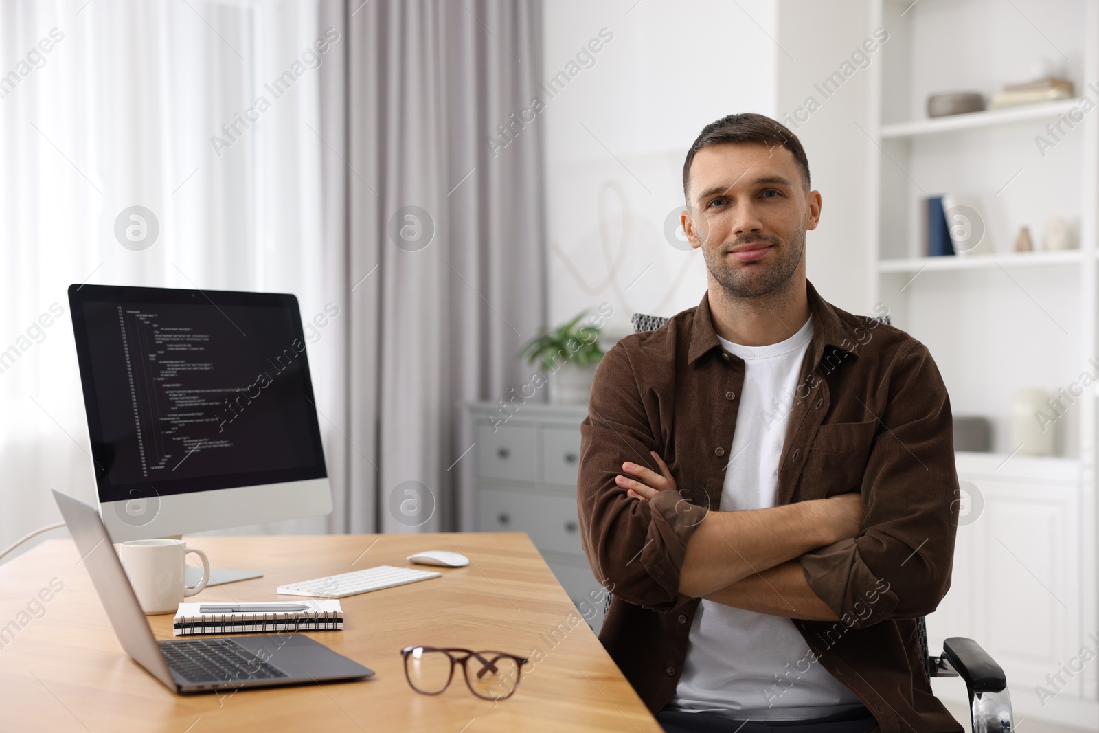 Photo of Portrait of programmer at wooden desk indoors