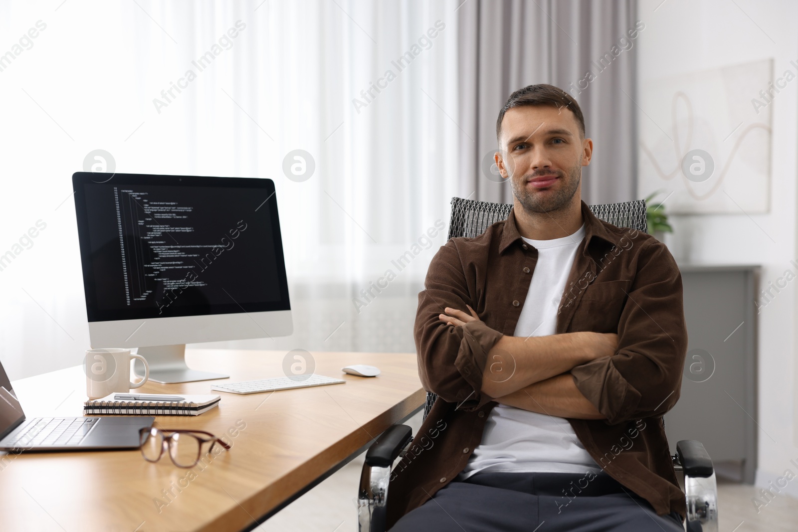 Photo of Portrait of programmer at wooden desk indoors