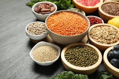 Photo of Superfood. Different healthy food products on grey table, closeup