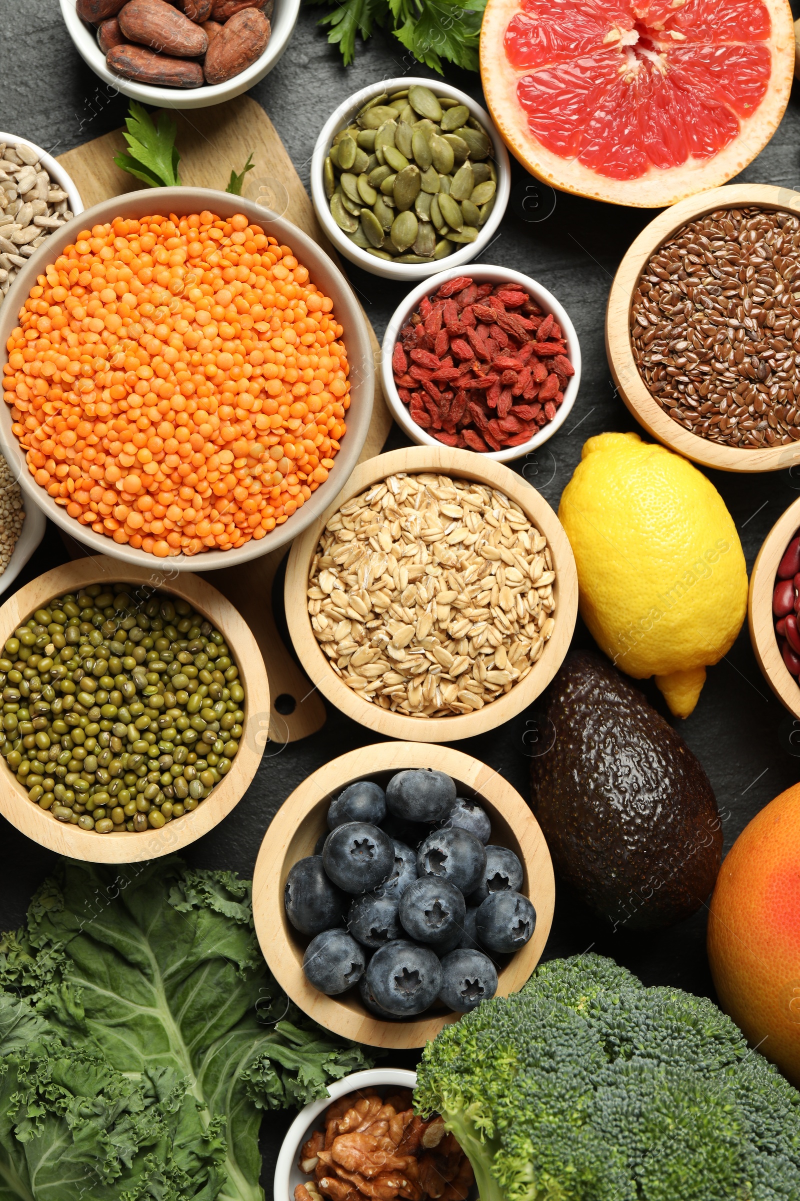 Photo of Superfood. Different healthy food products on grey table, flat lay