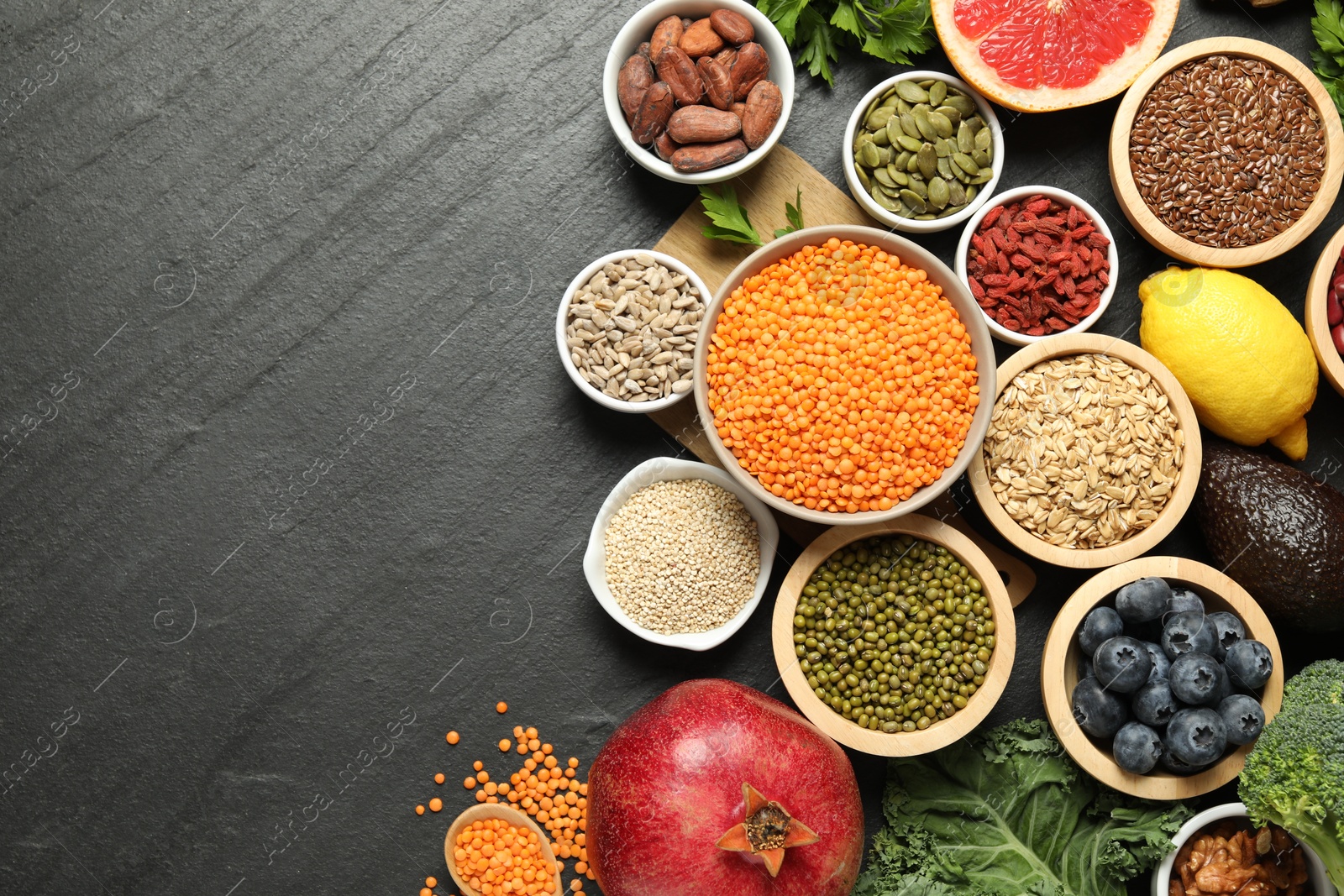 Photo of Superfood. Different healthy food products on grey table, flat lay. Space for text