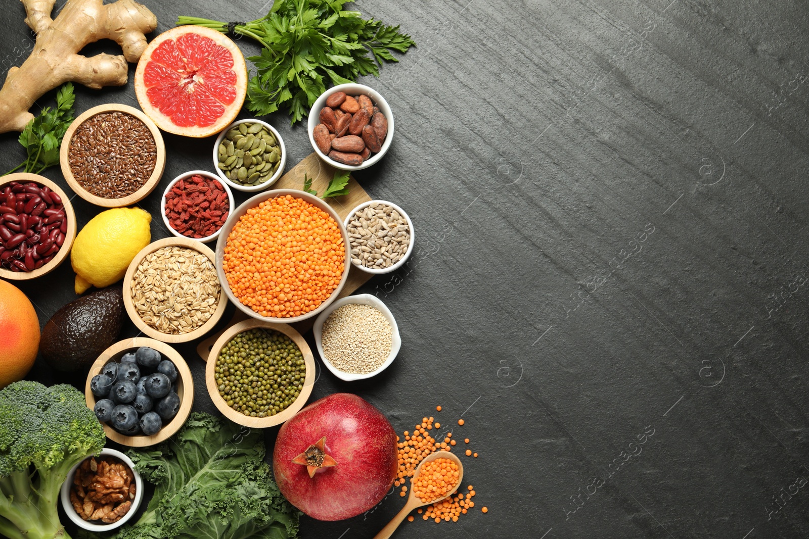 Photo of Superfood. Different healthy food products on grey table, flat lay. Space for text