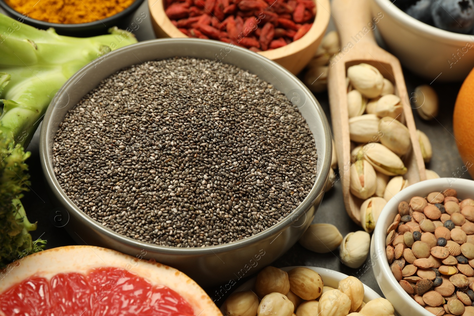 Photo of Superfood. Different healthy food products on grey table, closeup