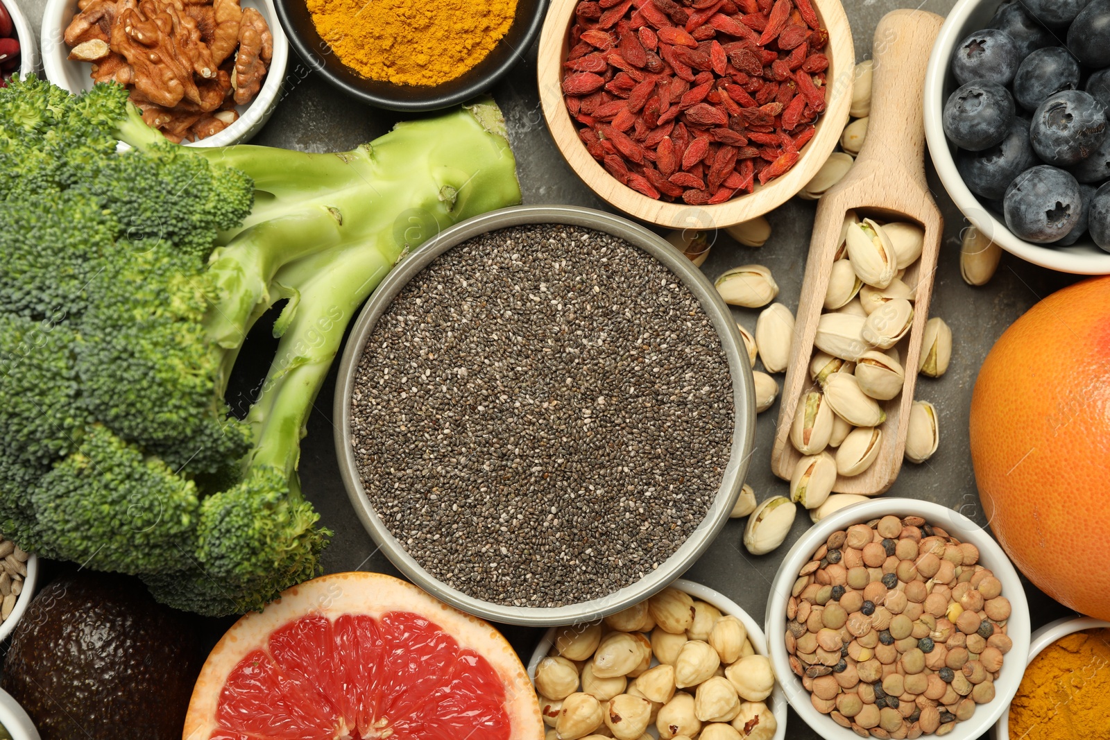 Photo of Superfood. Different healthy food products on grey table, flat lay