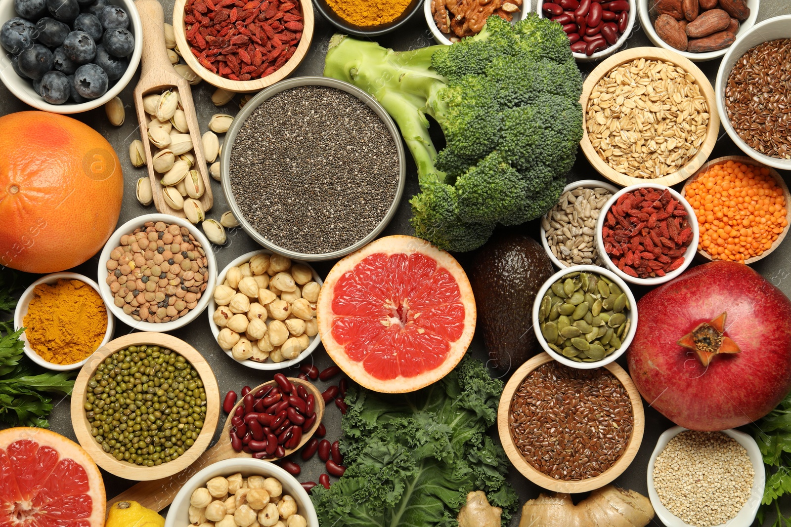 Photo of Superfood. Different healthy food products on grey table, flat lay