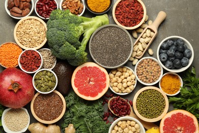 Photo of Superfood. Different healthy food products on grey table, flat lay