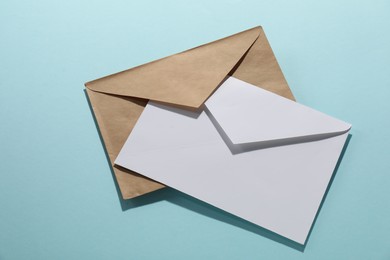 Photo of Paper envelopes on light blue background, top view. Mockup for design