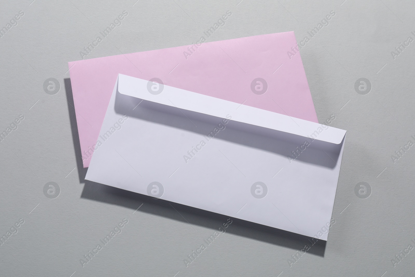 Photo of Paper envelopes on grey background, top view. Mockup for design