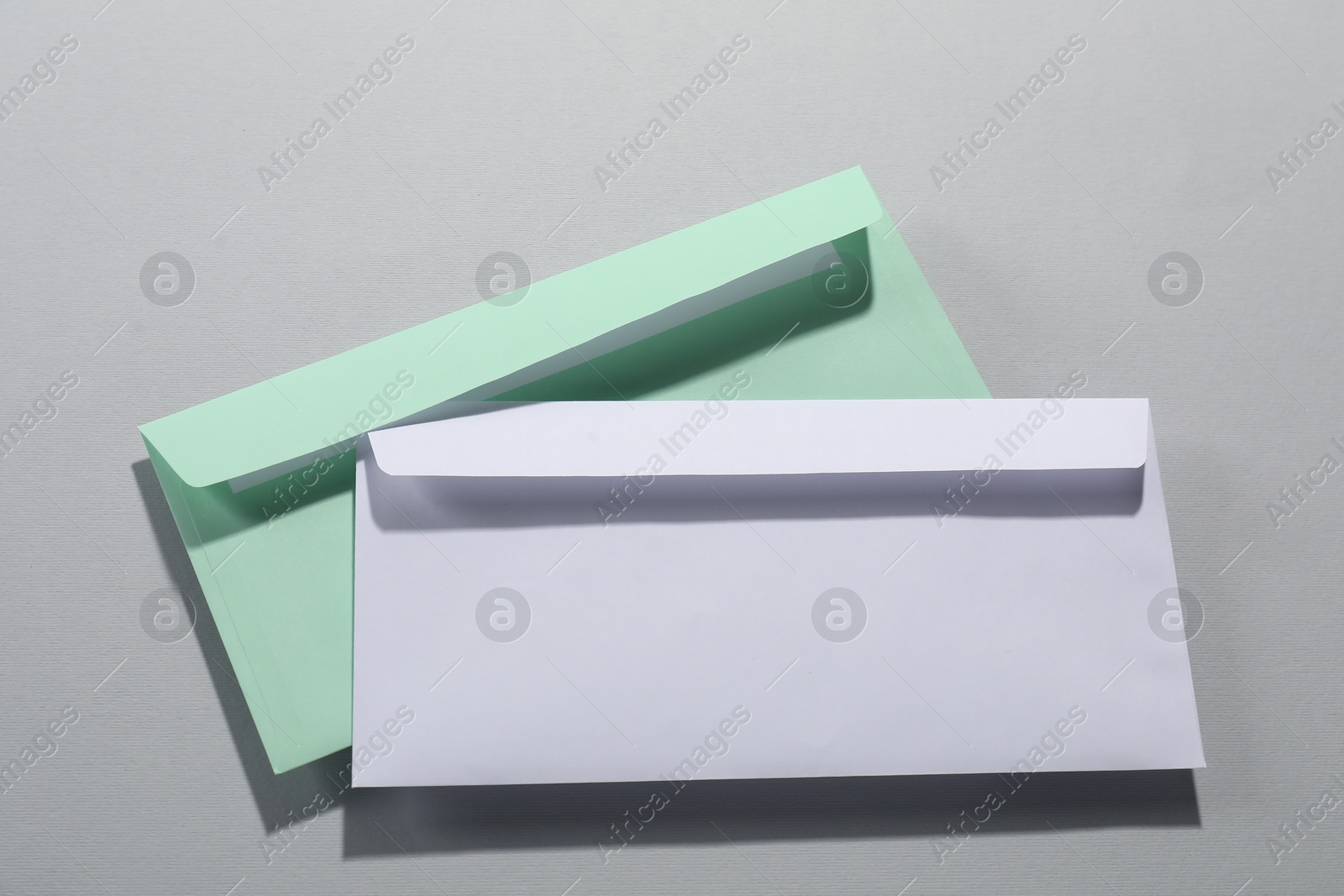 Photo of Paper envelopes on grey background, above view. Mockup for design