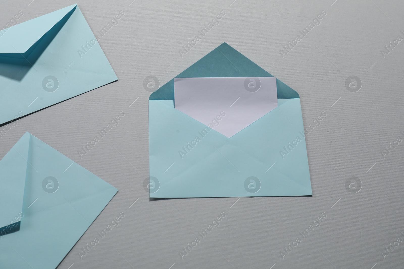 Photo of Paper envelopes with letter on grey background, flat lay. Mockup for design