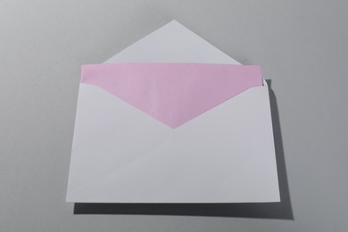 Paper envelope with letter on grey background, above view. Mockup for design