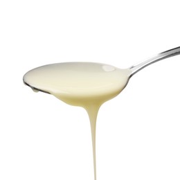 Photo of Delicious condensed milk pouring from spoon isolated on white