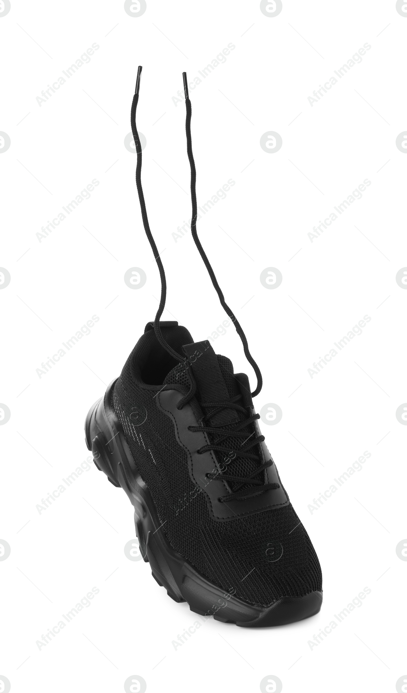 Photo of One black sneaker in air isolated on white