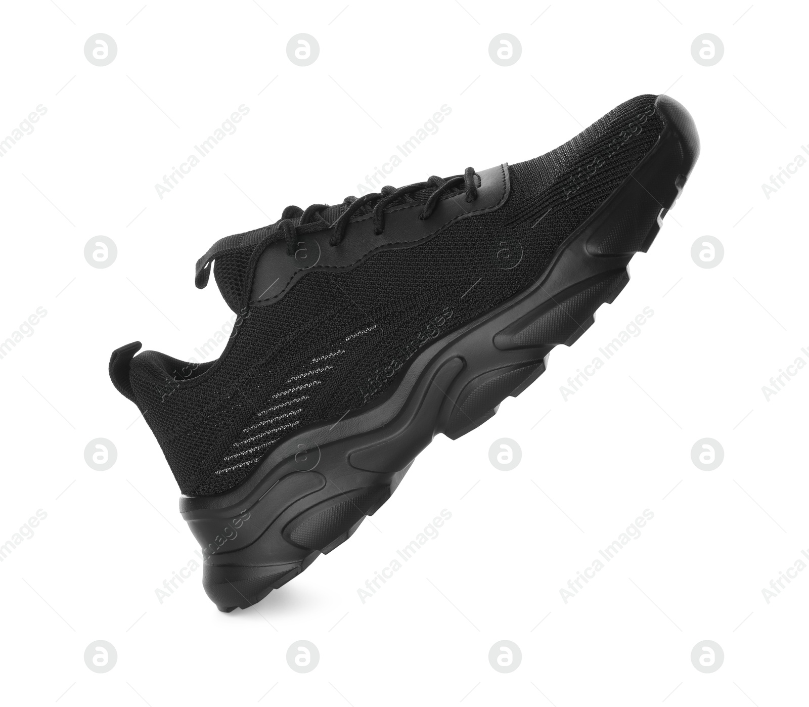 Photo of One black sneaker in air isolated on white