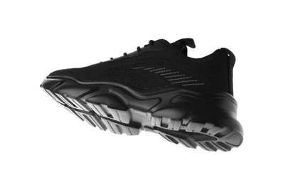 Photo of One black sneaker in air isolated on white