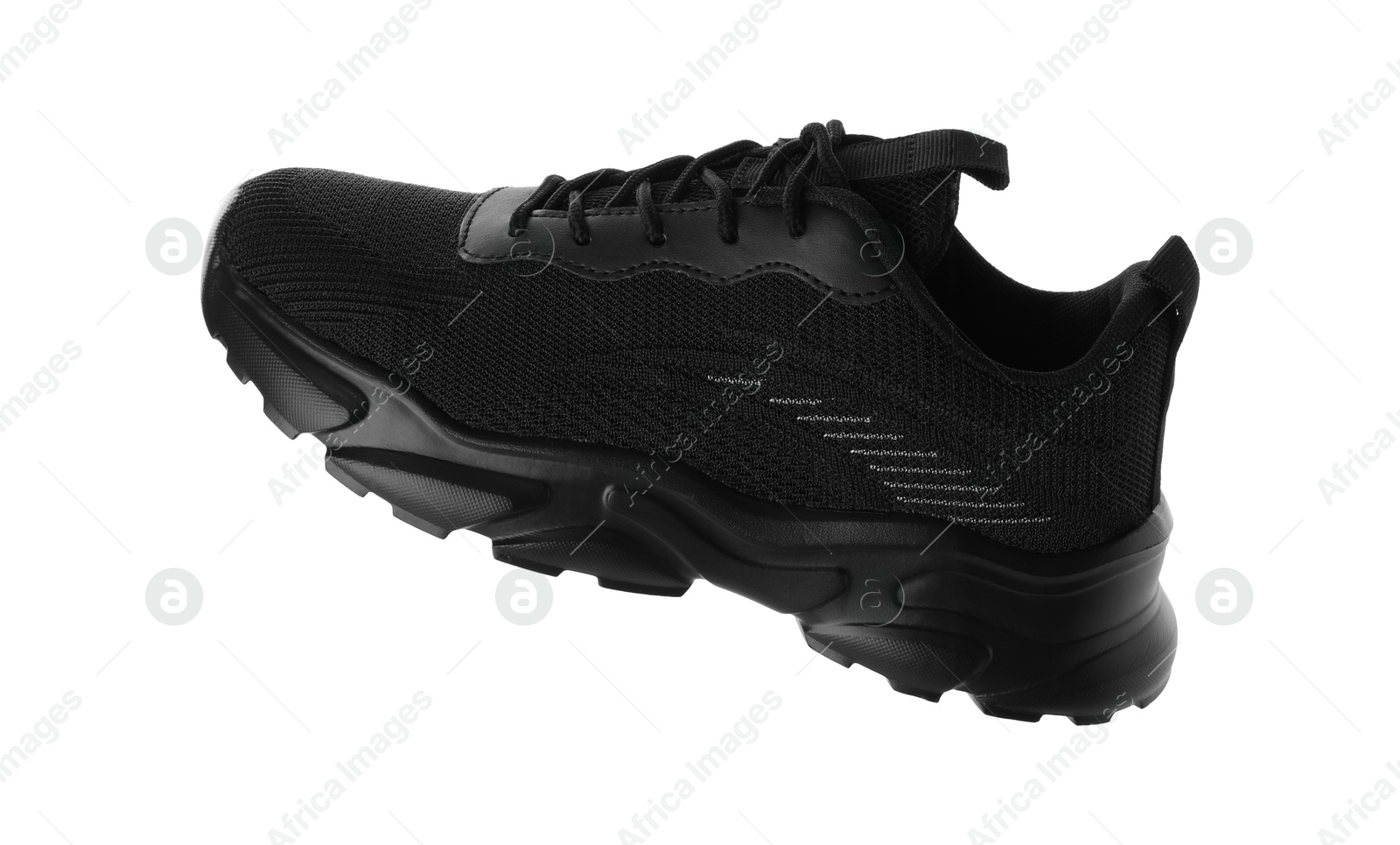 Photo of One black sneaker in air isolated on white