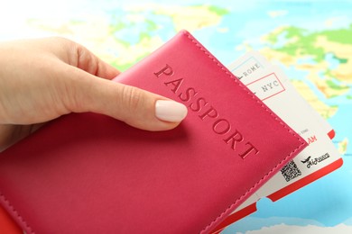 Photo of Woman with passport and flight tickets near world map, closeup