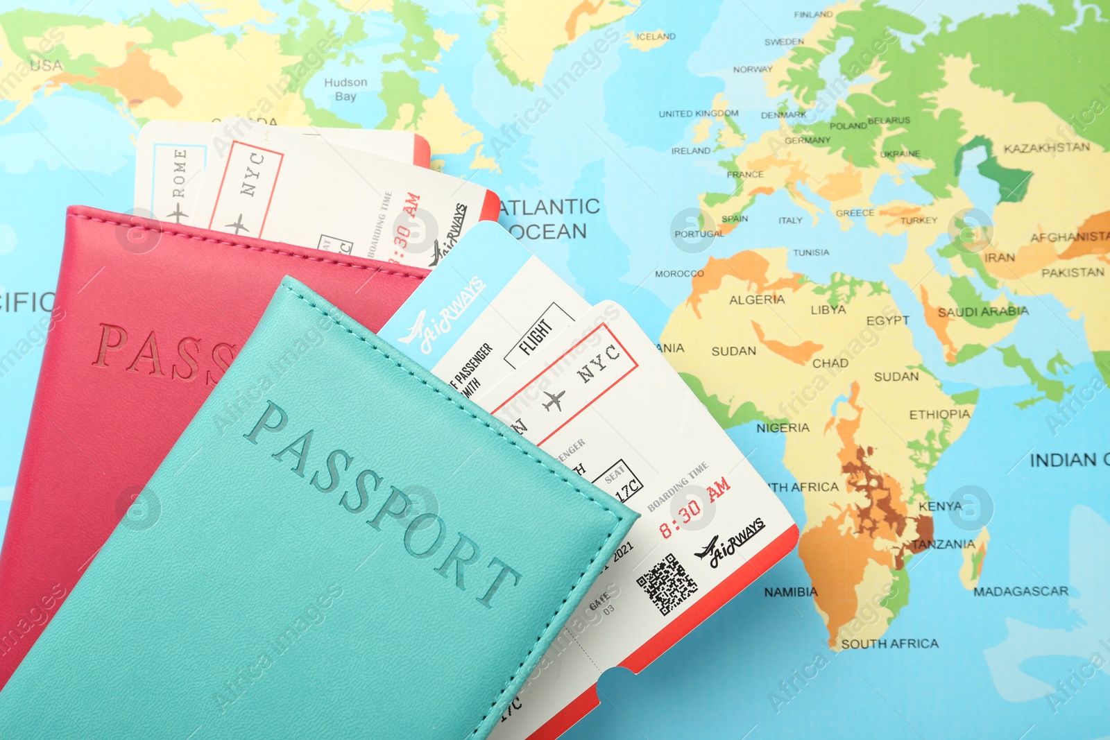 Photo of Passports in color covers and flight tickets on world map, top view. Space for text