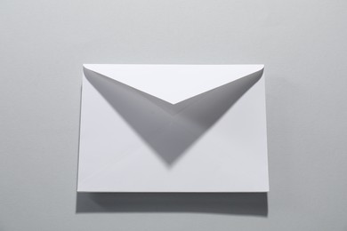 Photo of Paper envelope on grey background, top view. Mockup for design