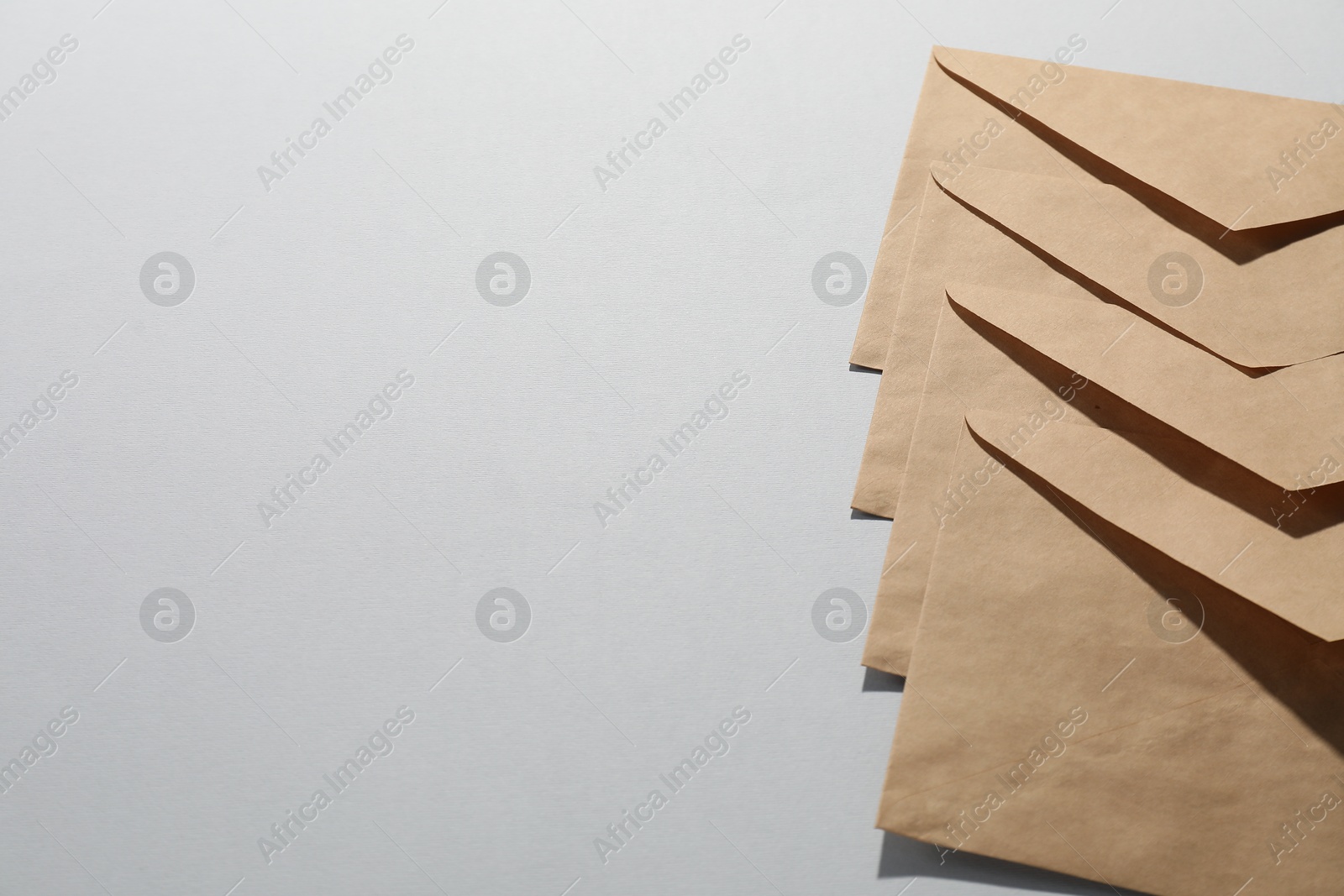 Photo of Kraft paper envelopes on grey background, above view. Mockup for design