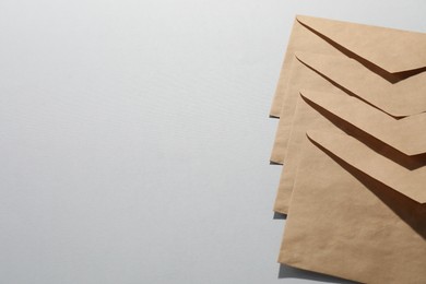 Kraft paper envelopes on grey background, above view. Mockup for design