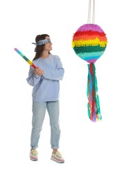 Woman with tied eyes breaking pinata on white background