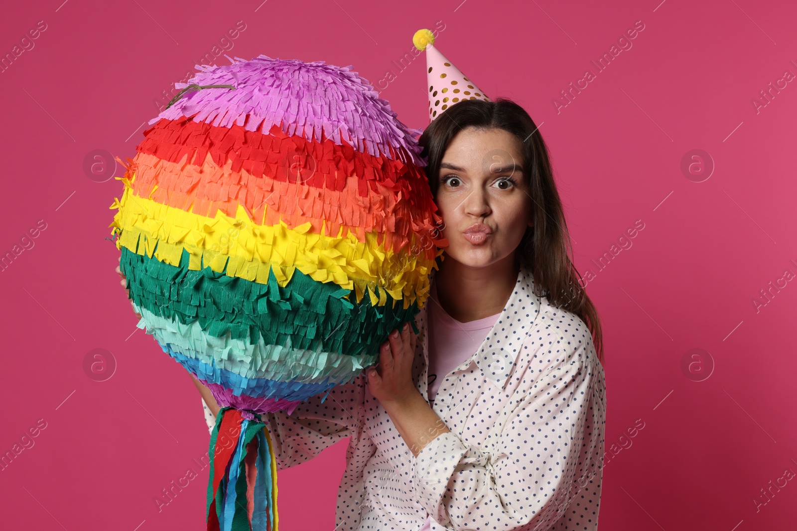 Photo of Woman with colorful pinata on pink background