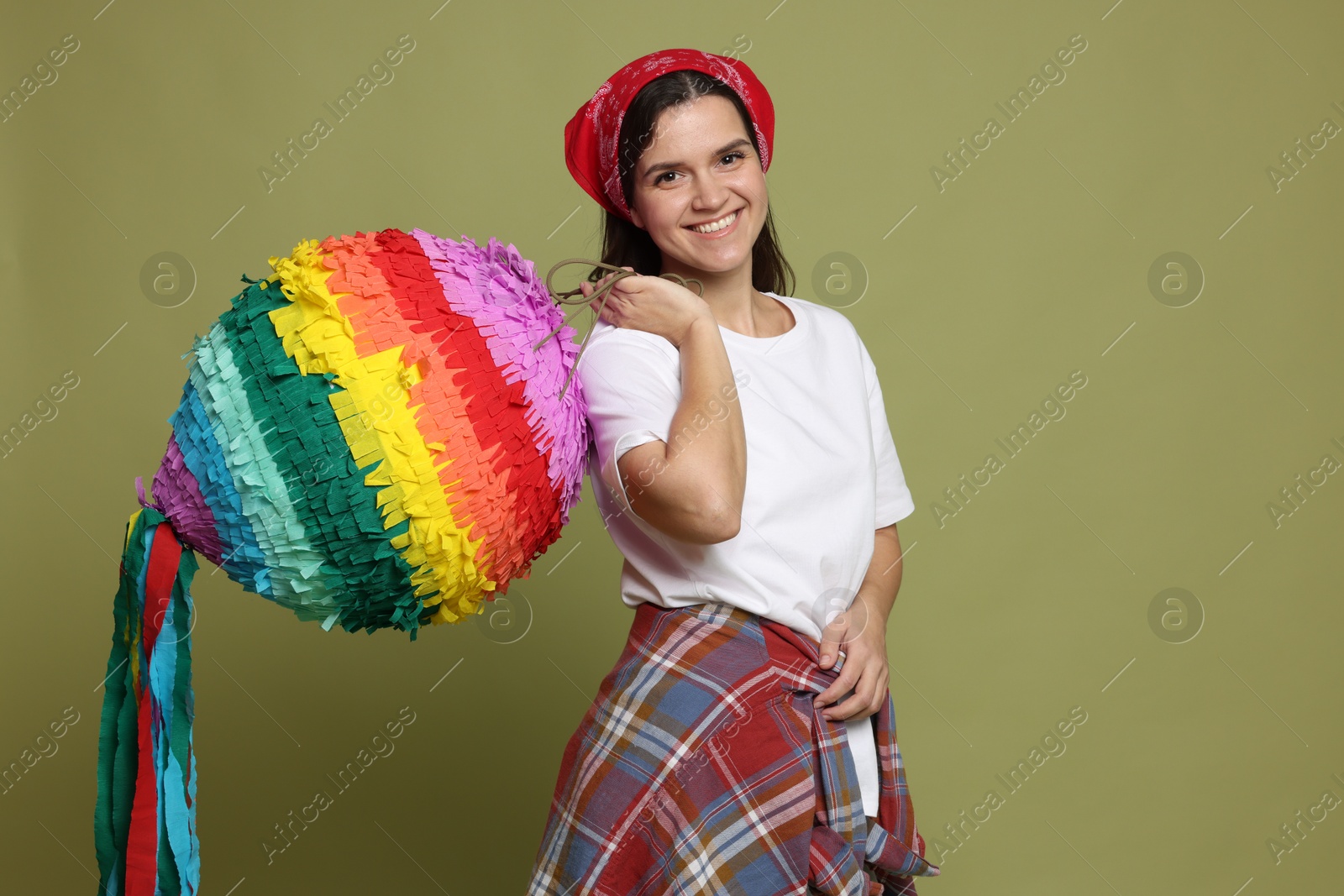 Photo of Happy woman with colorful pinata on green background