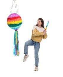 Happy woman hitting colorful pinata with stick on white background