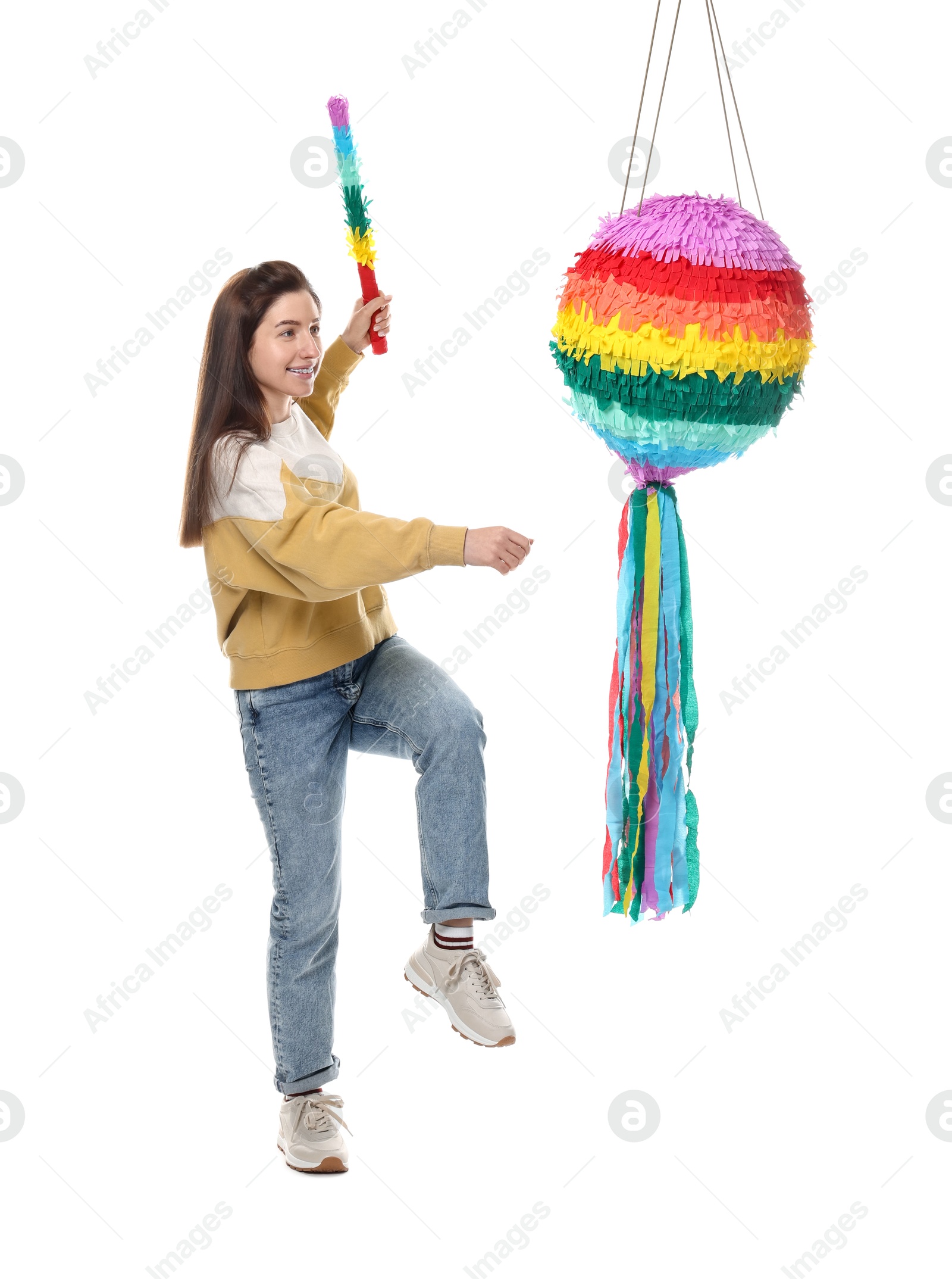 Photo of Happy woman hitting colorful pinata with stick on white background