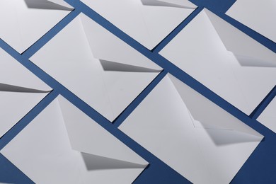 Photo of Paper envelopes on blue background, above view. Mockup for design