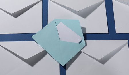 Photo of Paper envelopes with letter on blue background, above view. Mockup for design