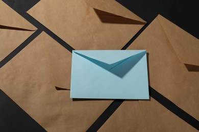 Photo of Paper envelopes on black background, above view. Mockup for design