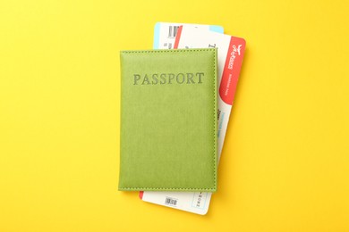 Photo of Passport with tickets on yellow background, top view