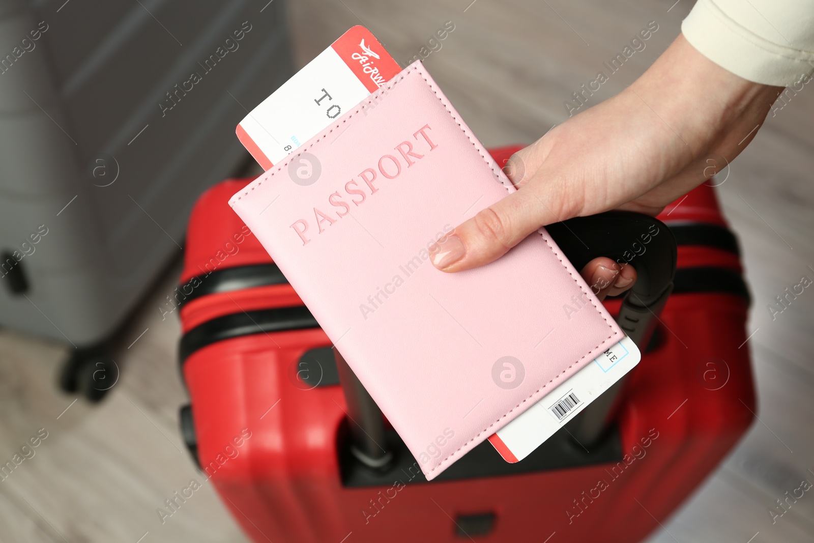 Photo of Woman with passport, ticket and suitcases indoors, closeup