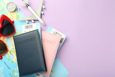 Photo of Passports with tickets, compass, map, sunglasses and airplane model on lilac background, flat lay. Space for text