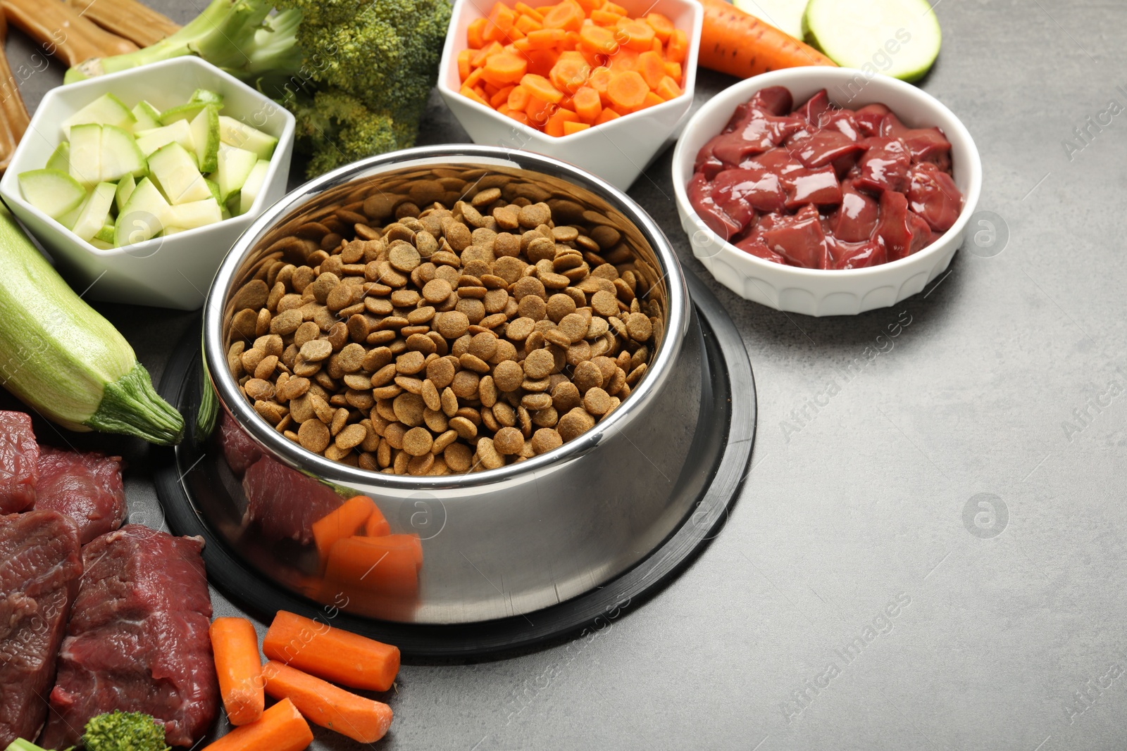 Photo of Dry pet food and natural products on grey table, closeup