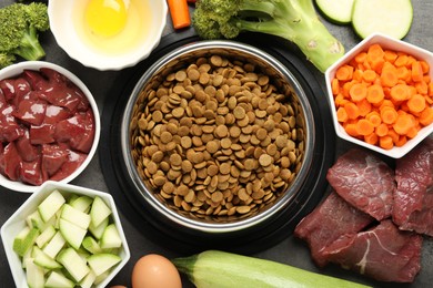 Photo of Dry pet food and natural products on grey table, top view