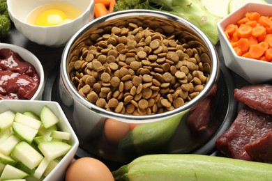 Photo of Dry pet food and natural products on grey table, closeup