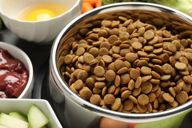 Photo of Dry pet food and natural products on grey table, closeup