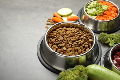 Photo of Dry pet food and natural products on grey table, closeup. Space for text