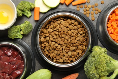 Photo of Dry pet food and natural products on grey table, top view