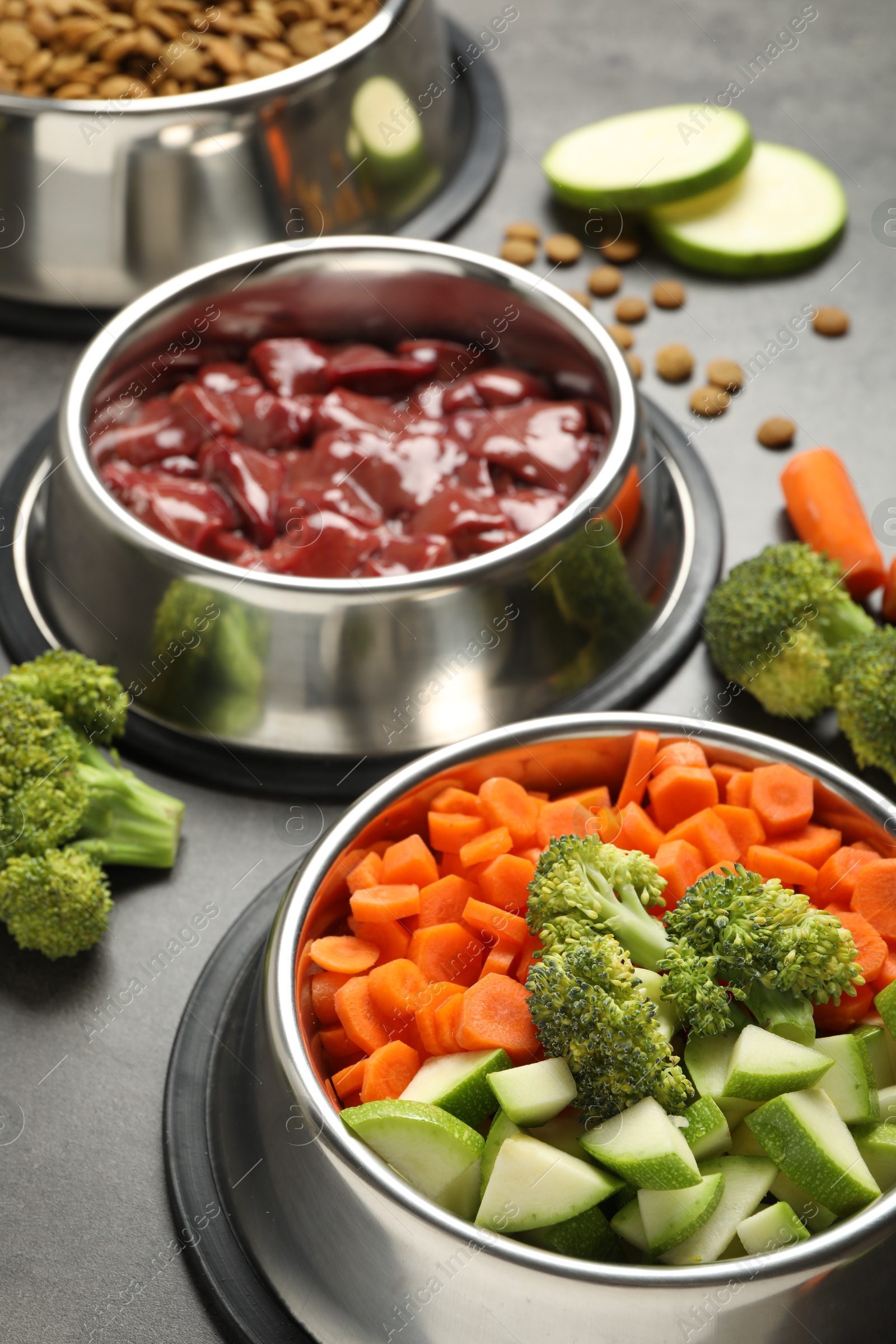 Photo of Dry pet food and natural products on grey table, closeup