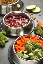 Photo of Dry pet food and natural products on grey table, closeup