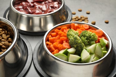 Photo of Dry pet food and natural products on grey table, closeup