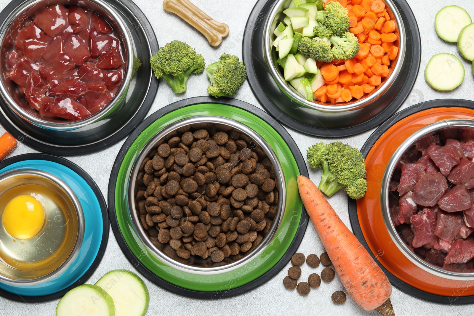 Photo of Dry pet food and natural products on light table, top view