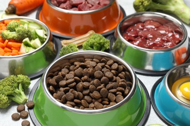 Photo of Dry pet food and natural products on light table, closeup